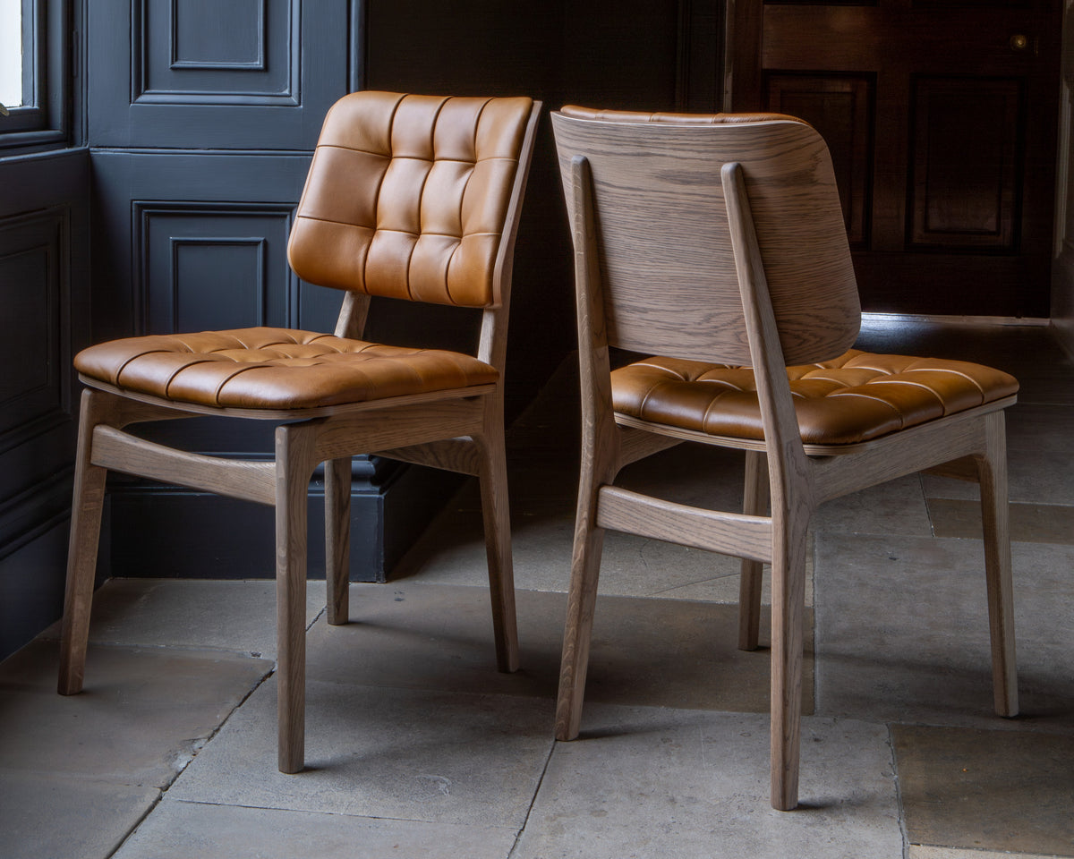 Carlton Furniture Pair of Boden Chairs upholstered seat and back in Tan Leather Grey oil legs — lifestyle setting