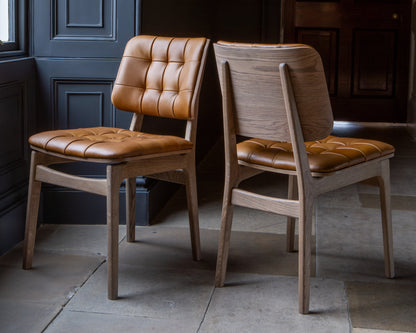 Carlton Furniture Pair of Boden Chairs upholstered seat and back in Tan Leather Grey oil legs — lifestyle setting