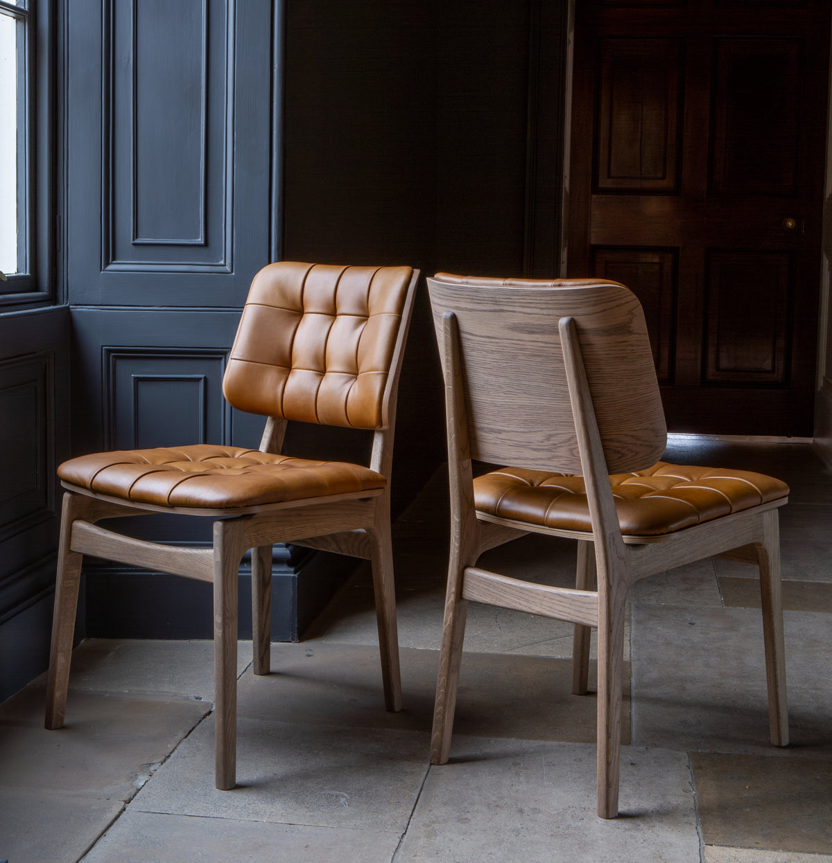 Carlton Furniture Pair of Boden Chairs upholstered seat and back in Tan Leather Grey oil legs — lifestyle setting