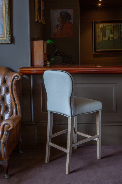Carlton Furniture Pavilion Barstool - Natural Linen Grey oil legs & Brass Studs — lifestyle setting