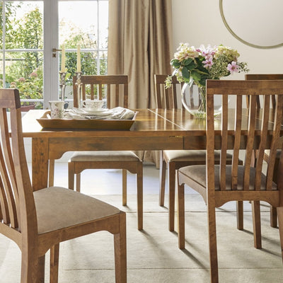 Garrat extending dining table by Laura Ashley in honey solid wood featuring a traditional design and smooth extension leaf.